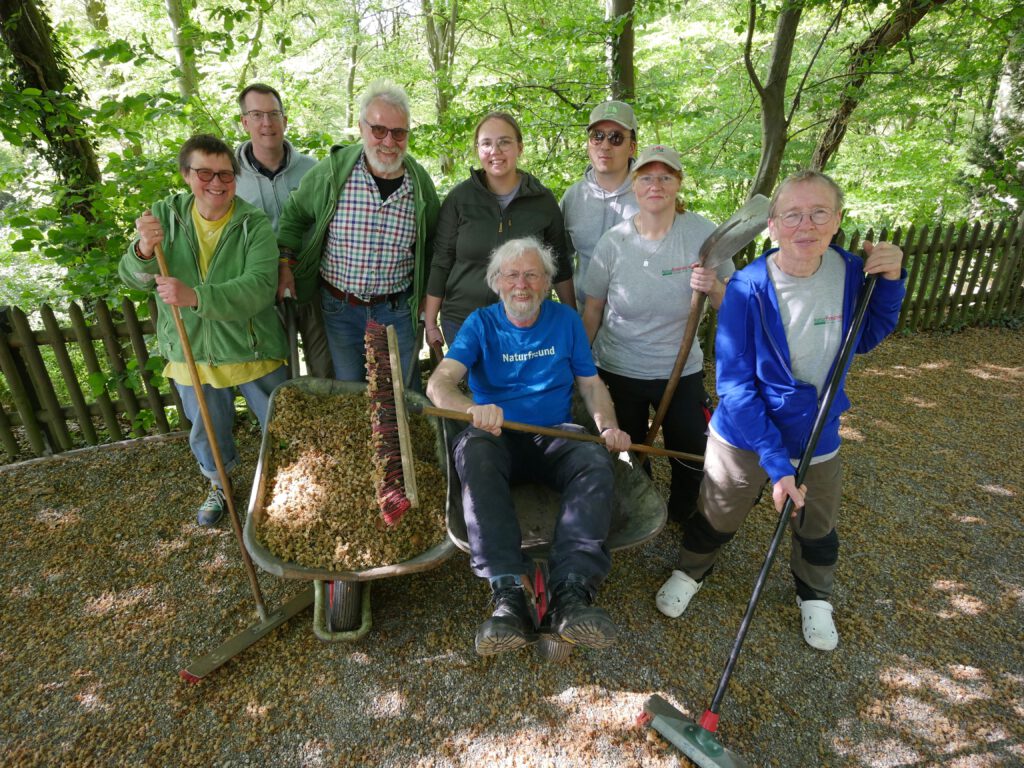 Gruppe mit Gartengeräten und Schubkarre auf dem Gelände des NaturFreundeHauses.
